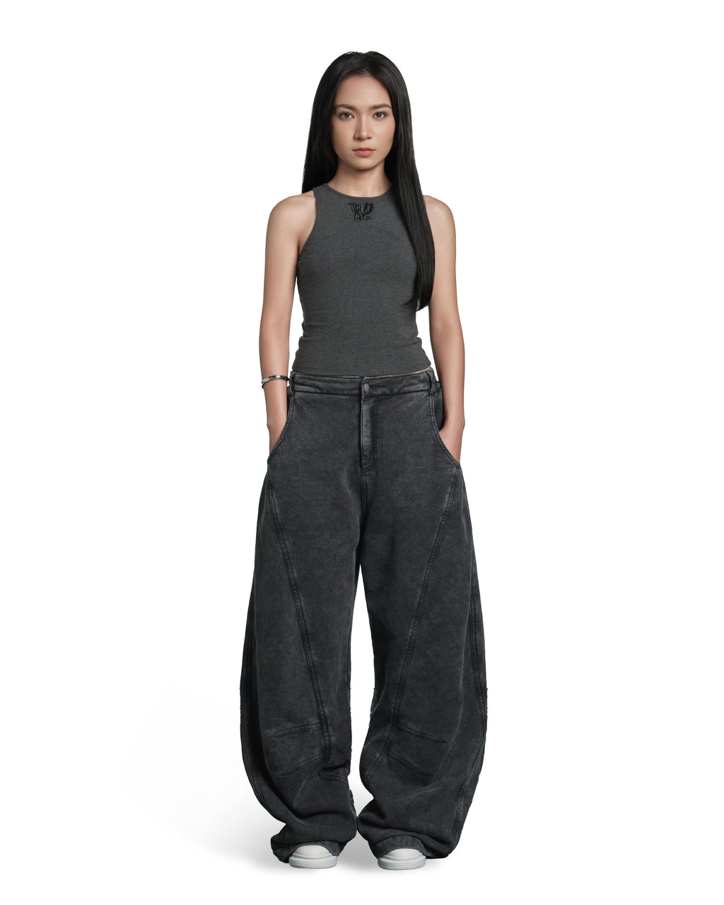 A model stands against a solid white background wearing a dark gray ribbed sleeveless top and matching dark gray wide-leg pants with a washed texture.