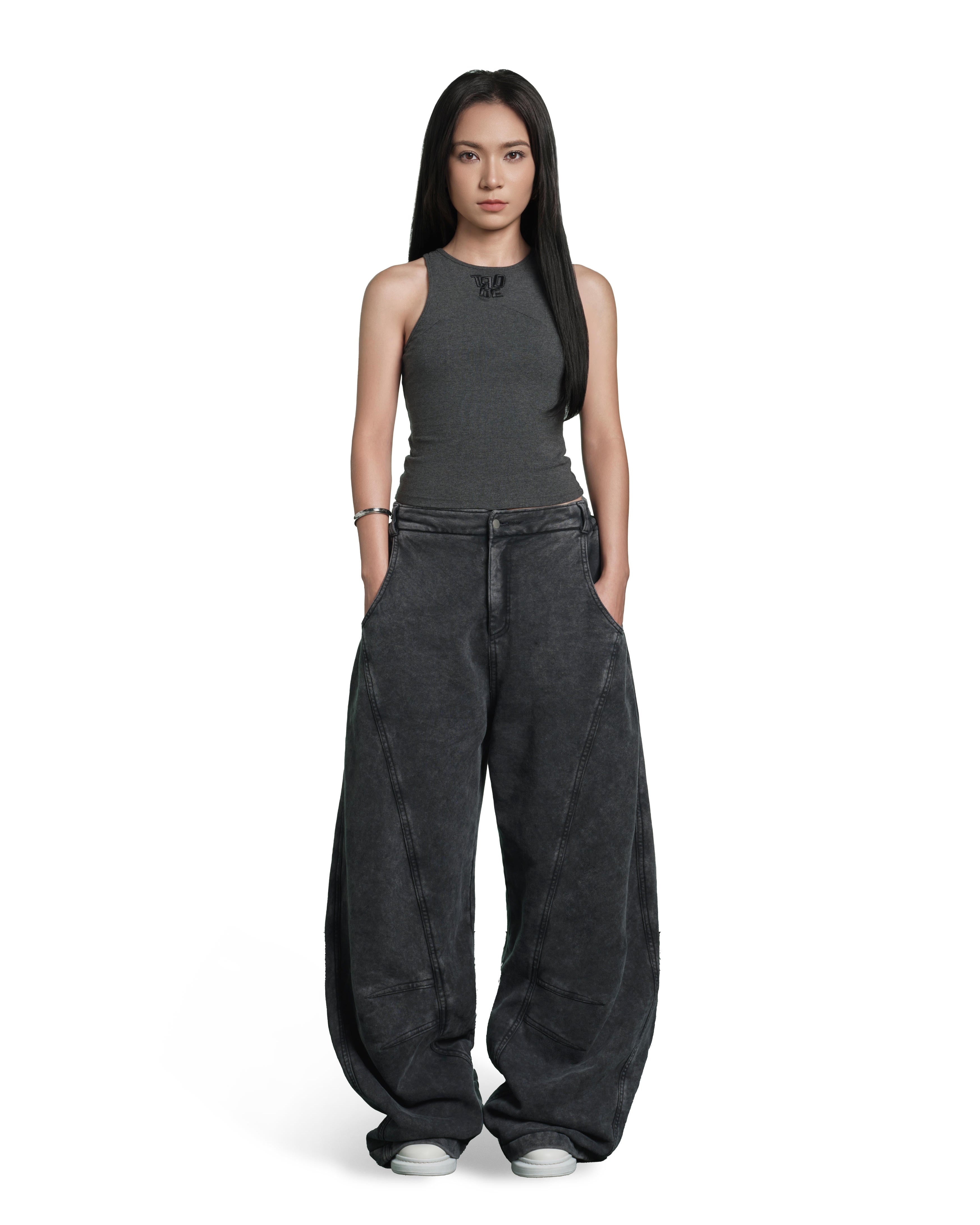 A model stands against a solid white background wearing a dark gray ribbed sleeveless top and matching dark gray wide-leg pants with a washed texture.